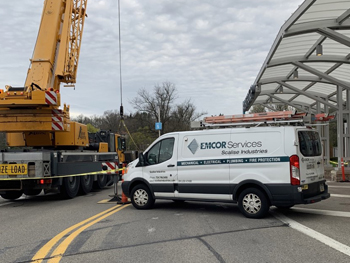 EMCOR Services Scalise Industries service truck near a crane